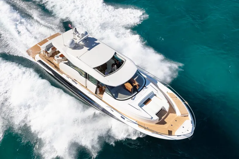 Slide: The Image of 2025 Tiara Yachts EX 60 cruising on clear blue water. - 5