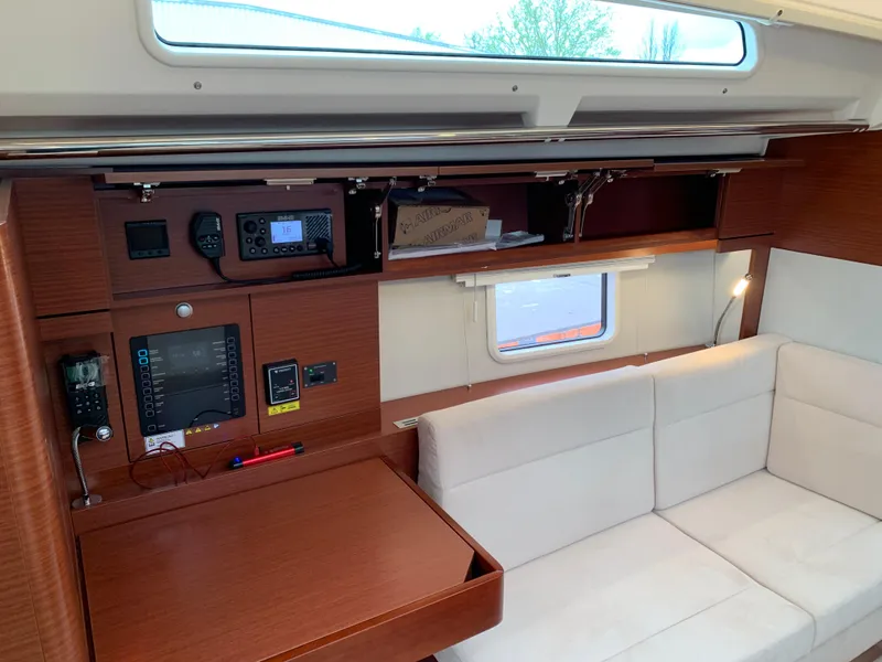 Slide: The Image of 2024 Hanse 388 yacht interior with navigation equipment and white seating. - 12