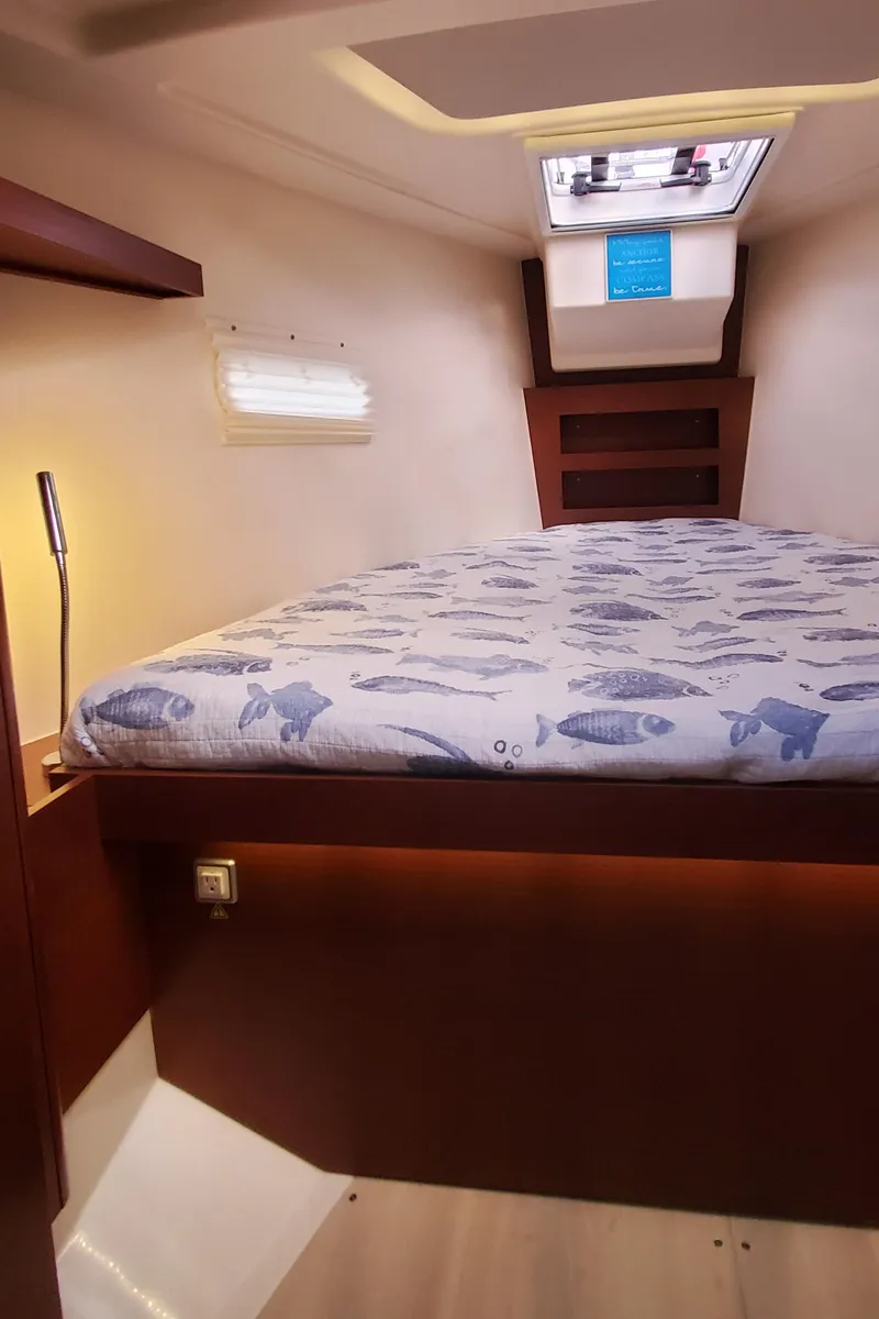 Slide: The Image of 2024 Hanse 388 yacht cabin with fish-patterned bedding and skylight. - 16