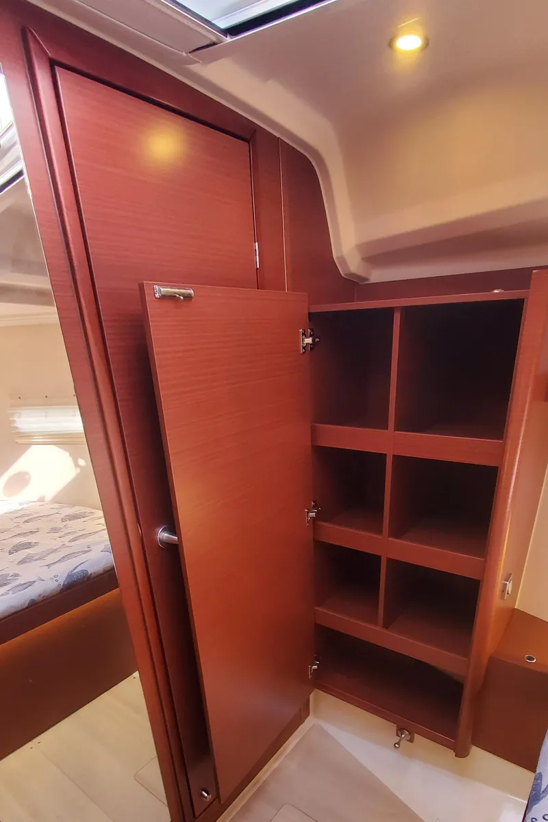 Slide: The Image of 2024 Hanse 388 yacht interior with open wooden cabinet and shelving. - 19