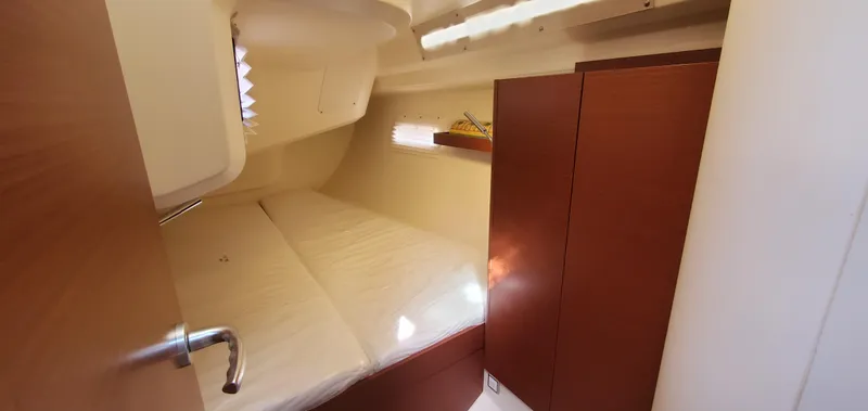 Slide: The Image of 2024 Hanse 388 yacht cabin interior with wooden finishes and cozy bed. - 26