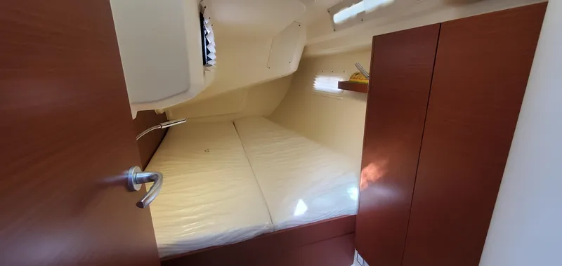 Slide: The Image of 2024 Hanse 388 yacht cabin interior with wooden finish and cozy bed. - 28