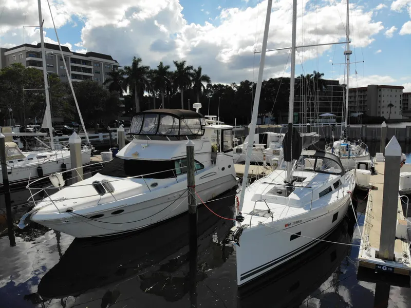 Slide: The Image of 2024 Hanse 388 yacht docked at marina, surrounded by other boats and palm trees. - 33