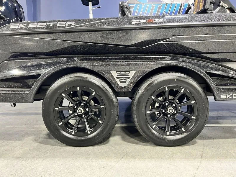 Slide: The Image of 2025 Skeeter FXR20 PRO boat trailer with black alloy wheels. - 13