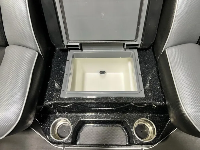 Slide: The Image of 2025 Skeeter FXR20 PRO boat interior with open storage compartment and cup holders. - 15