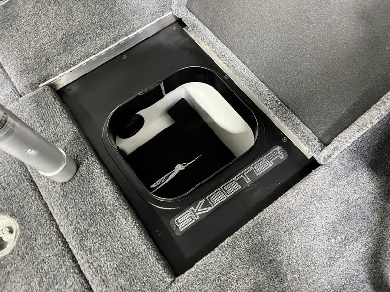Slide: The Image of 2025 Skeeter FXR20 PRO boat storage compartment with logo, featuring carpeted interior. - 17