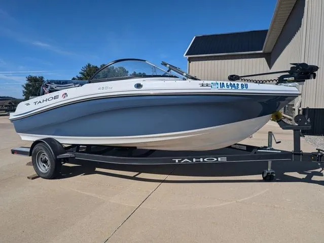Slide: The Image of 2021 Tracker 450 TF boat on trailer, parked outdoors under clear blue sky. - 18