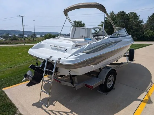 Slide: The Image of 2007 Crownline 190 SS boat on trailer, parked near a scenic lake view. - 3