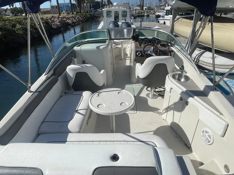 Slide: The Image of 2010 Sea Ray 260 Sundeck boat interior with seating and helm, docked in marina. - 7
