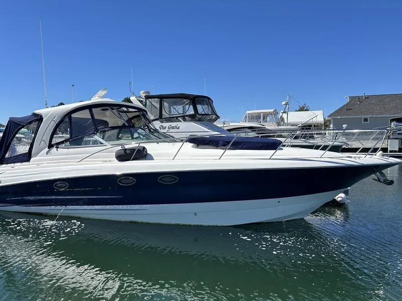 The Image of 2010 Larson Cabrio 370 boat docked in marina under clear blue sky. - 0