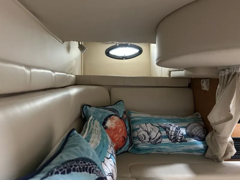 Slide: The Image of Cozy interior of 2010 Larson Cabrio 370 with nautical-themed pillows. - 12
