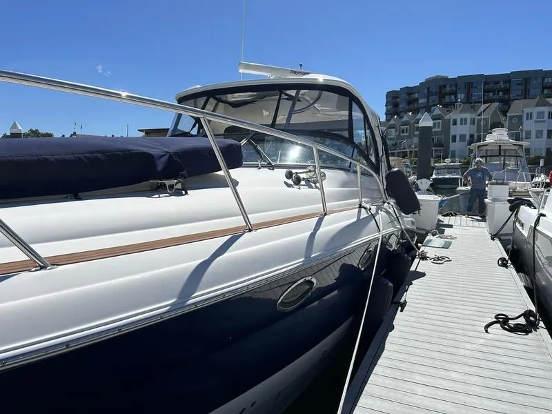 Slide: The Image of 2010 Larson Cabrio 370 yacht docked at marina under clear blue sky. - 23