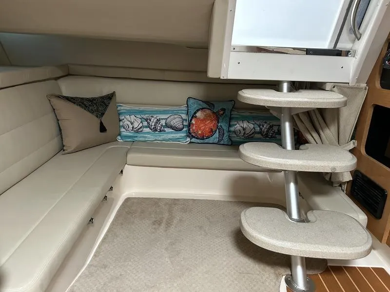 Slide: The Image of Interior of 2010 Larson Cabrio 370 boat with beige seating and decorative pillows. - 5