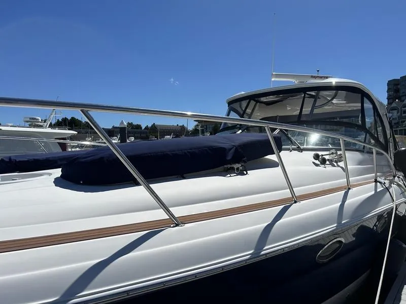 Slide: The Image of 2010 Larson Cabrio 370 yacht with sleek design, docked under clear blue sky. - 6