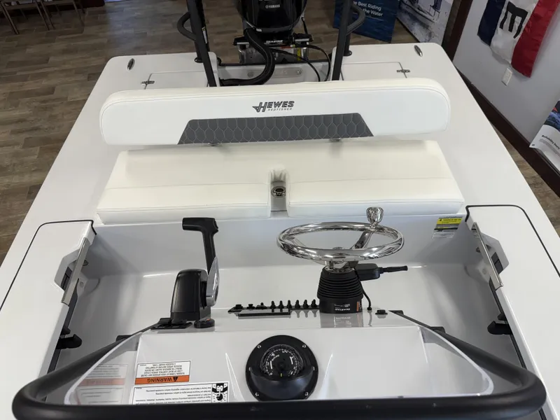 Slide: The Image of 2025 Hewes 18 Redfisher boat interior with steering wheel and controls. - 10