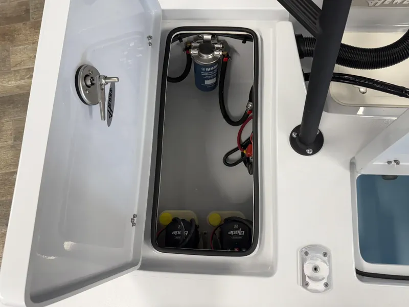 Slide: The Image of Open storage compartment in 2025 Hewes 18 Redfisher boat, showing internal components and wiring. - 15