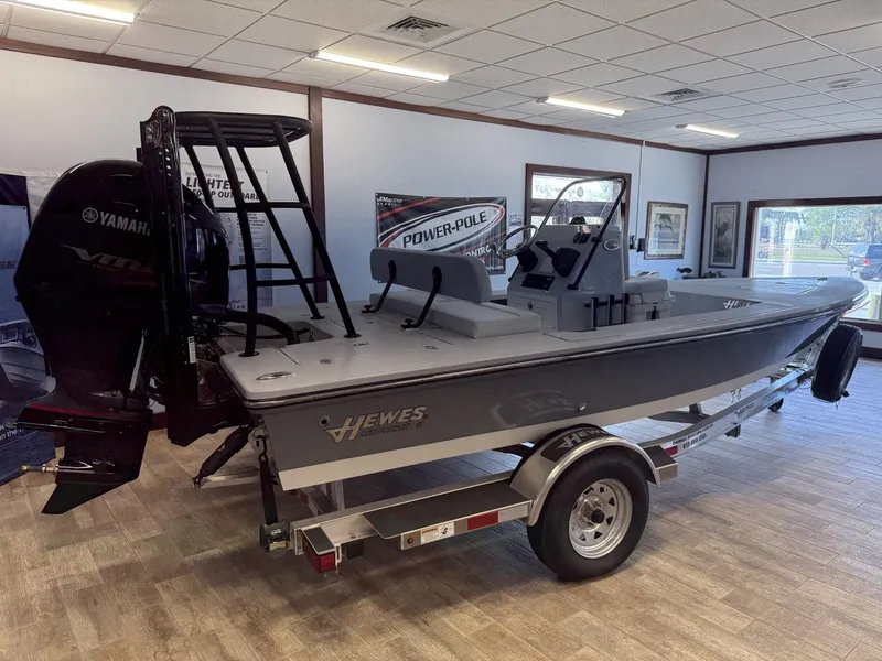 Slide: The Image of 2025 Hewes 18 Redfisher boat with Yamaha engine on display in showroom. - 18