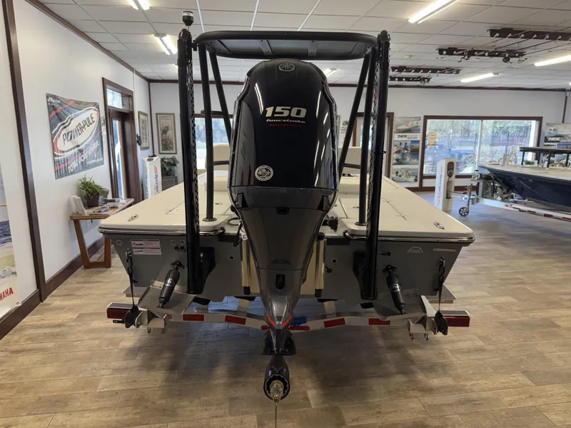 Slide: The Image of 2025 Hewes 18 Redfisher boat with 150 horsepower engine displayed indoors. - 19