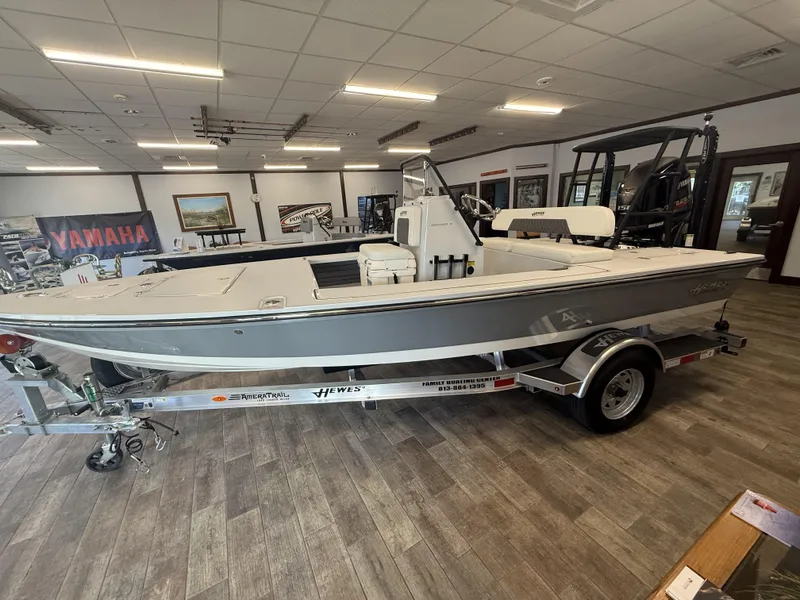 Slide: The Image of 2025 Hewes 18 Redfisher boat displayed indoors on a trailer. - 20