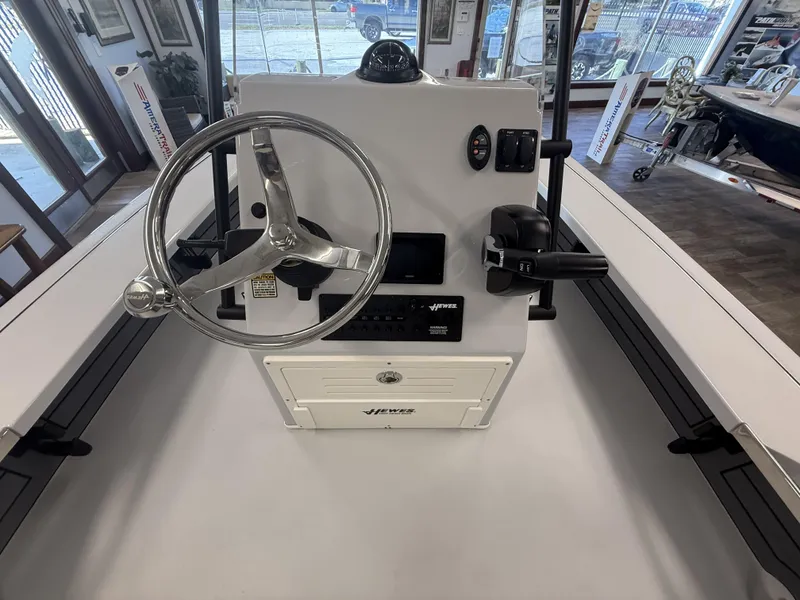 Slide: The Image of 2025 Hewes 18 Redfisher boat console with steering wheel and controls in showroom. - 21