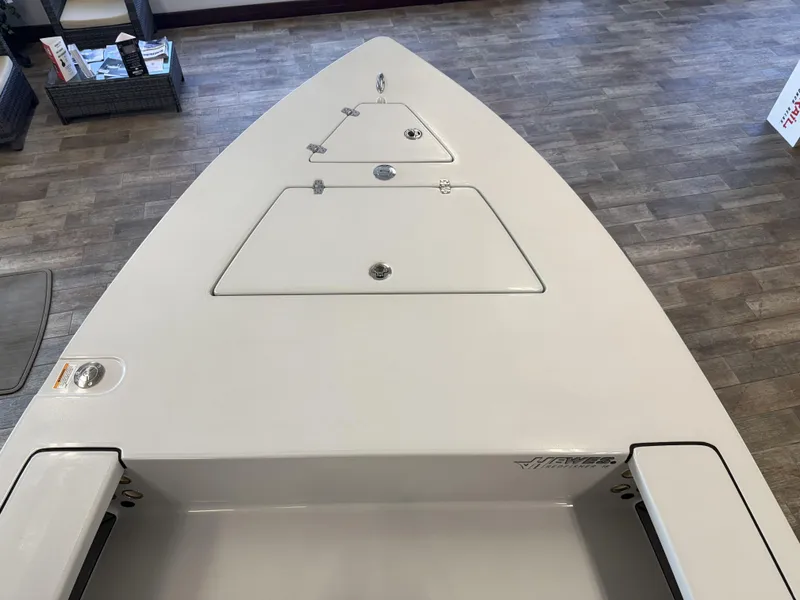 Slide: The Image of 2025 Hewes 18 Redfisher boat deck with storage compartments, displayed indoors. - 24