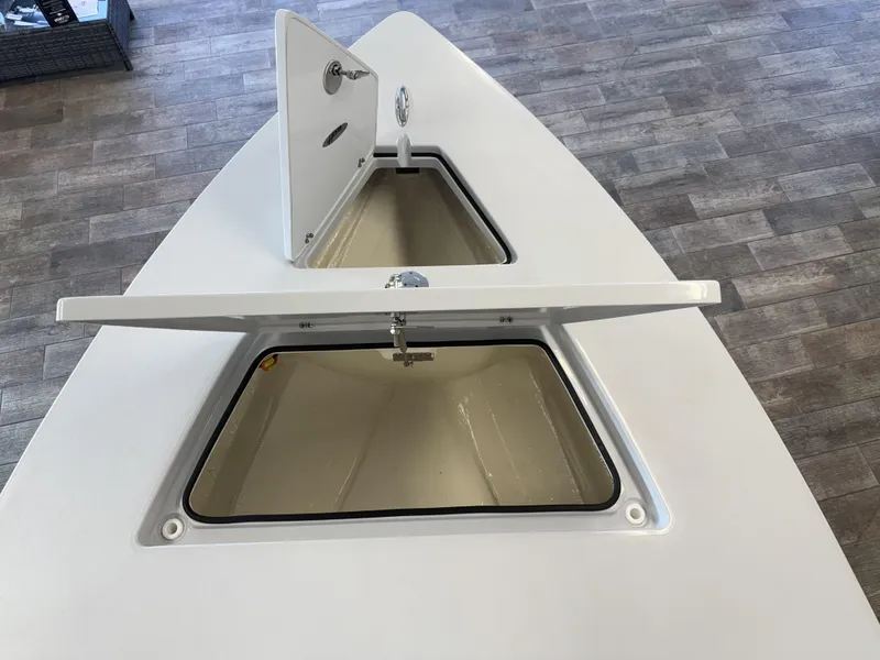 Slide: The Image of 2025 Hewes 18 Redfisher boat storage compartments open on a wooden floor. - 28