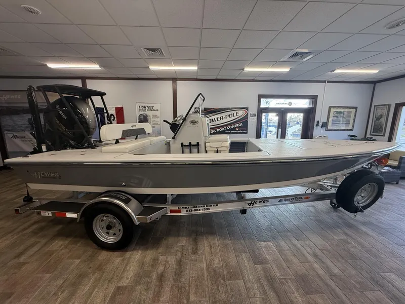 Slide: The Image of 2025 Hewes 18 Redfisher boat displayed indoors on a trailer. - 3