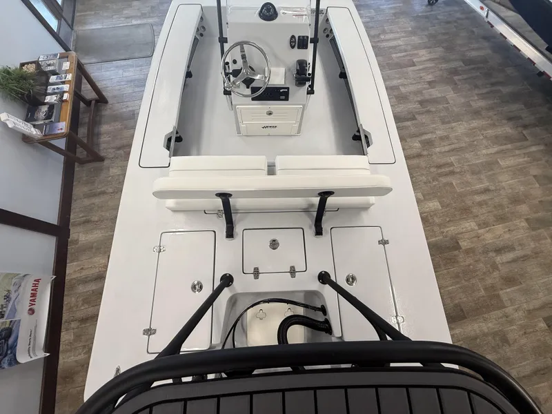 Slide: The Image of 2025 Hewes 18 Redfisher boat interior with steering console and seating, displayed indoors. - 7