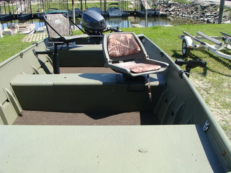 Slide: The Image of 2023 Crestliner 1648 Jon boat with camo seats, docked near a marina. - 5