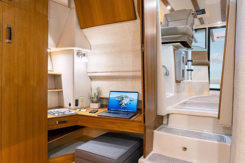 Slide: The Image of 2025 Ranger Tugs R-43 S interior with modern workspace and stairs. - 24