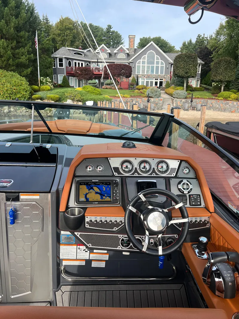 Slide: The Image of 2016 Cruisers Yachts 338 SOUTH BEACH dashboard with navigation system, steering wheel, and luxurious interior. - 11