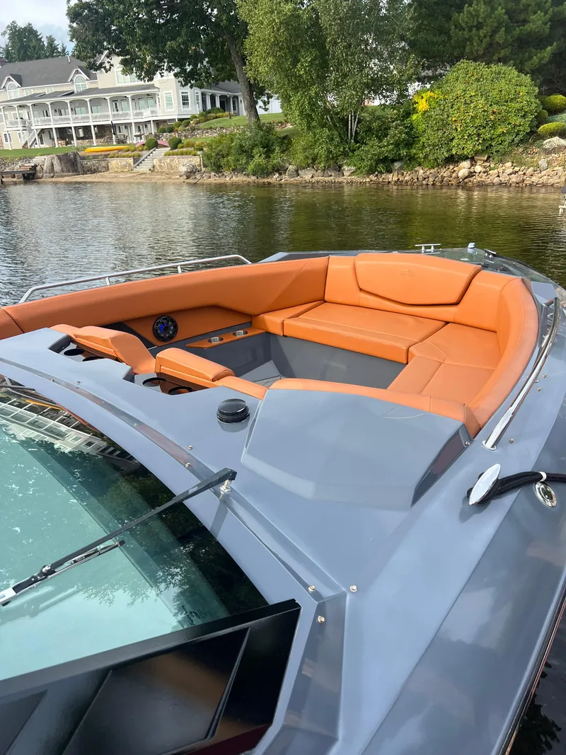 Slide: The Image of 2016 Cruisers Yachts 338 SOUTH BEACH with orange seating, docked by a scenic waterfront. - 6