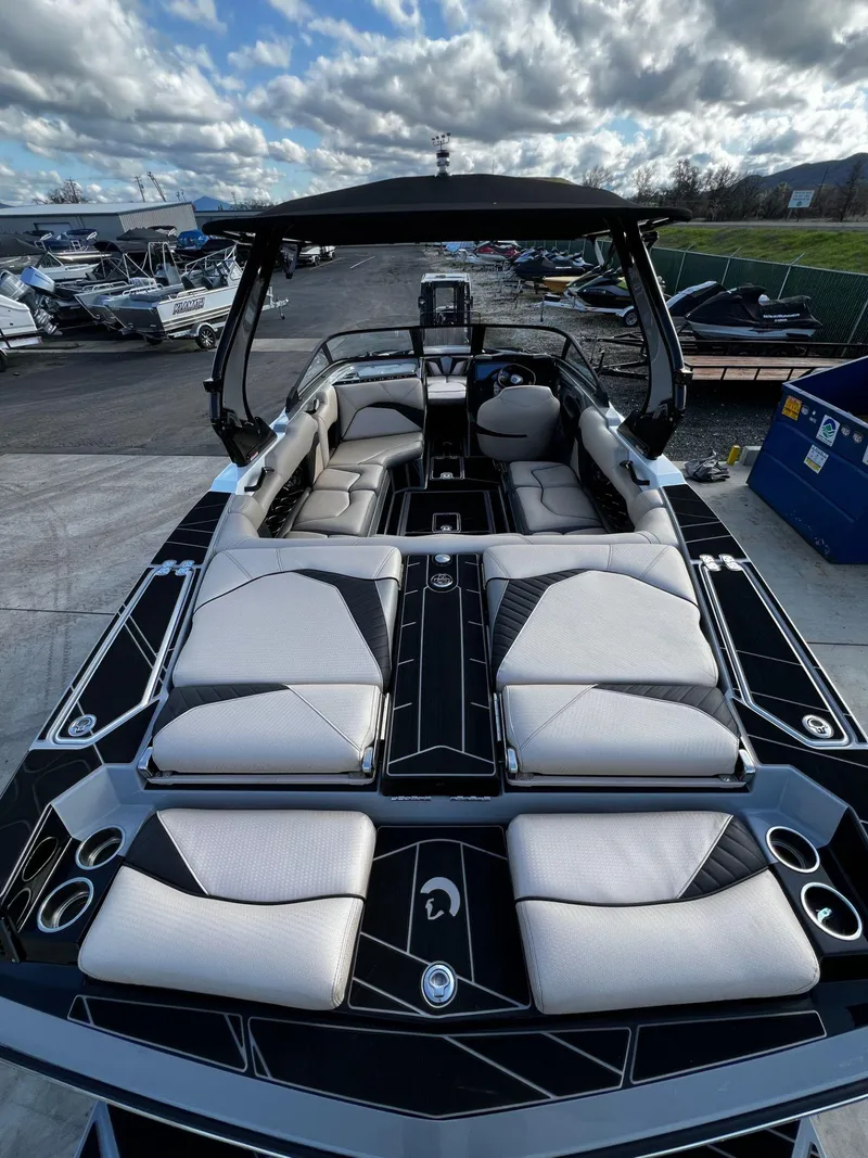 Slide: The Image of 2024 Centurion Fi23 boat with luxurious seating and sleek design under a cloudy sky. - 7