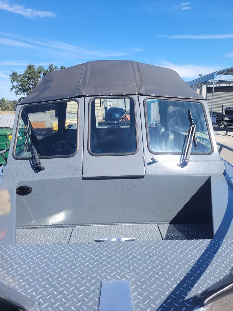 Slide: The Image of 2024 Boulton Powerboats Sentinel Pro 22 with windshield and canopy, docked under clear sky. - 8