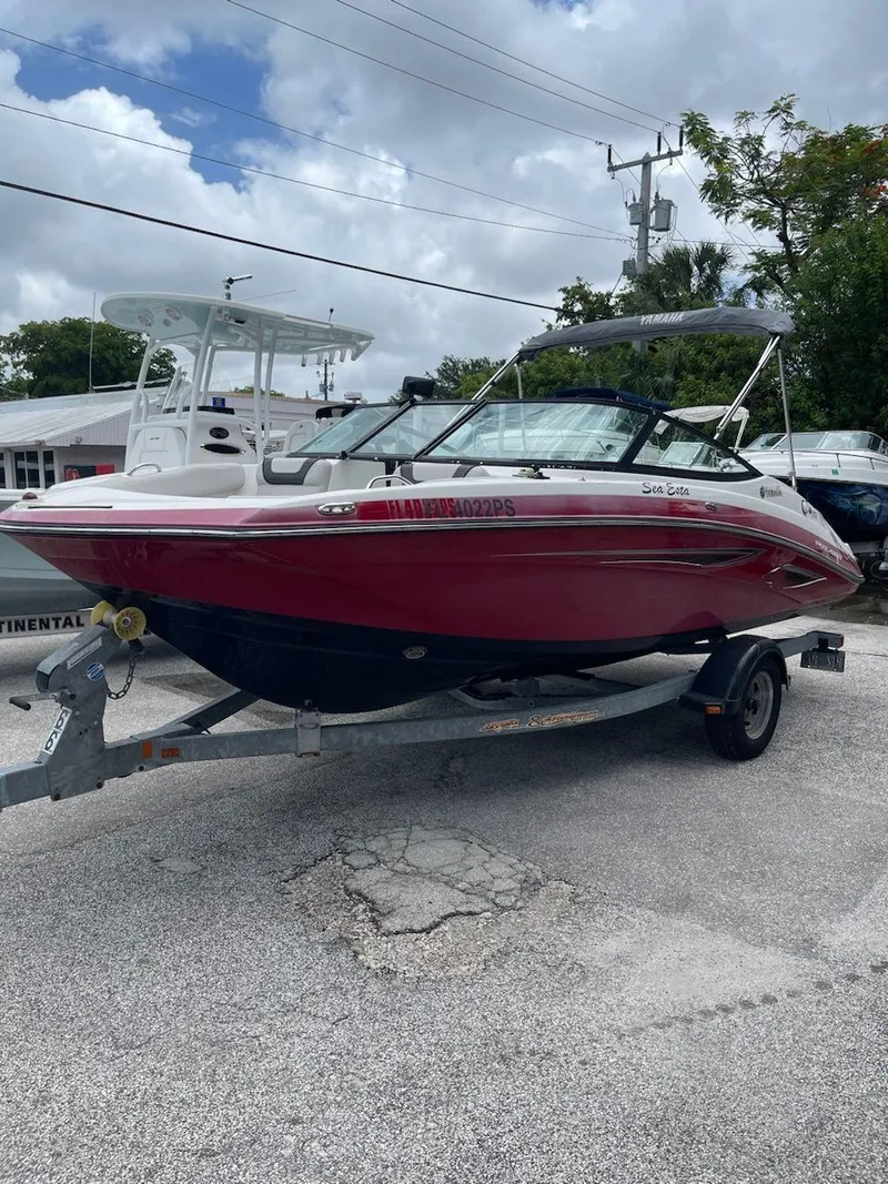 Slide: The Image of 2014 Yamaha Boats SX192 on trailer, red and white, parked outdoors. - 1