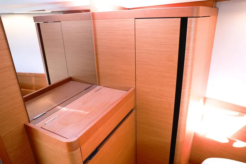 Slide: The Image of Interior of 2022 Jeanneau Sun Odyssey 410 yacht, featuring sleek wooden cabinetry. - 13