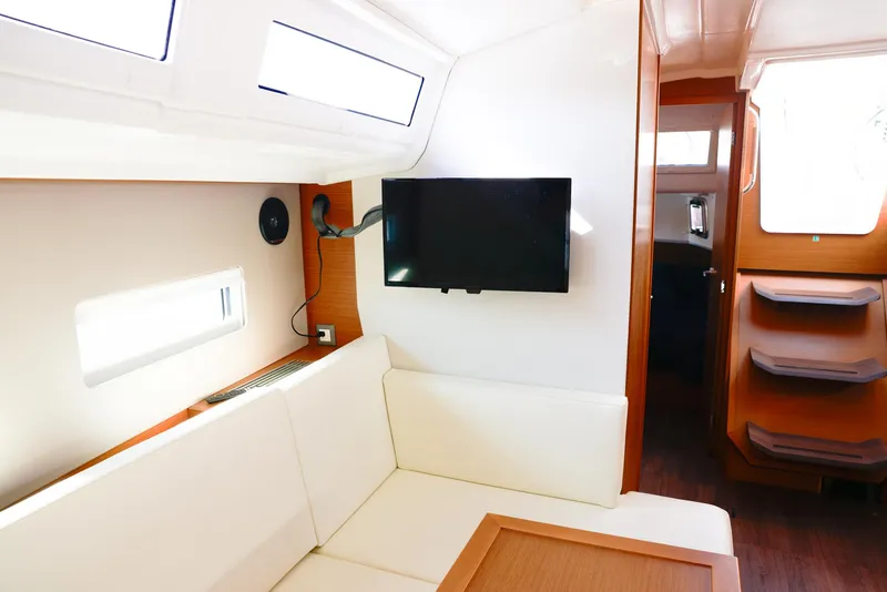 Slide: The Image of Interior of 2022 Jeanneau Sun Odyssey 410 yacht with modern seating and mounted TV. - 7