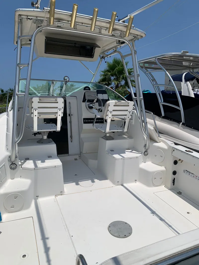 Slide: The Image of 2000 Robalo 2640 Walkaround boat with dual seats and fishing rod holders. - 12