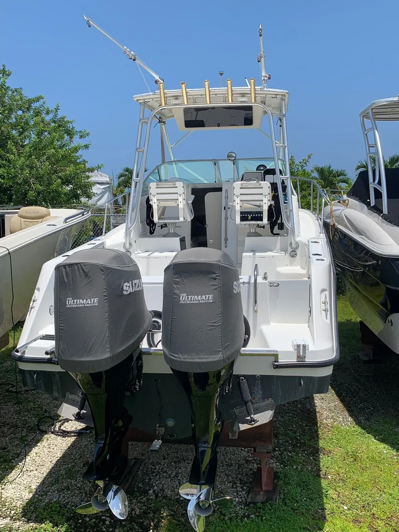 Slide: The Image of 2000 Robalo 2640 Walkaround boat with dual Suzuki outboard motors. - 16