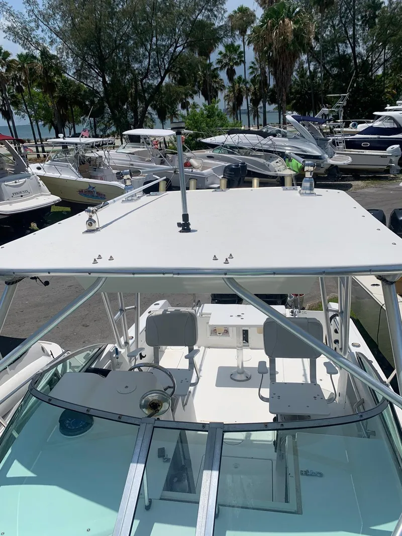 Slide: The Image of 2000 Robalo 2640 Walkaround boat docked, surrounded by trees and other boats. - 24