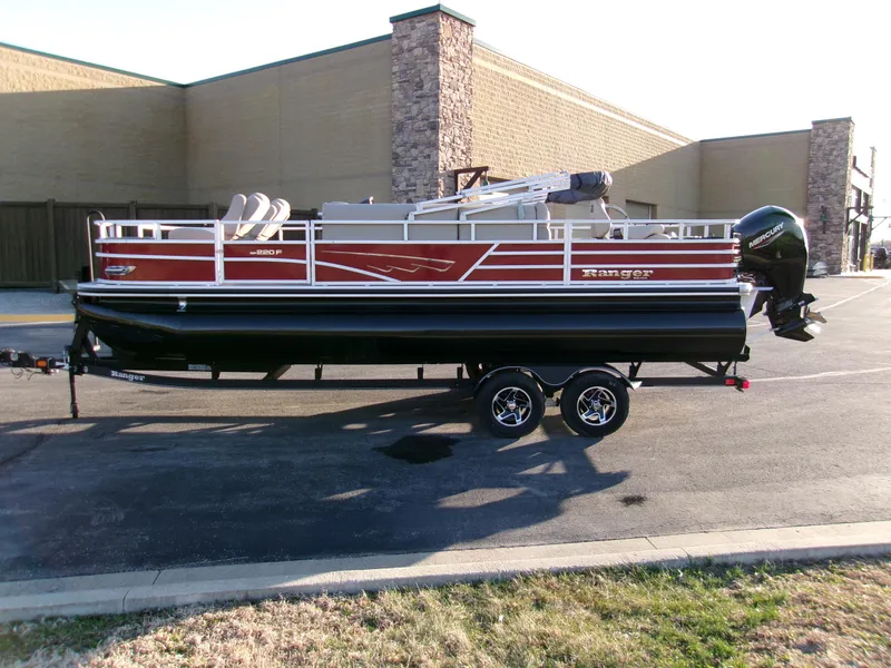 Slide: The Image of 2024 Ranger Reata 220F pontoon boat on trailer, parked outdoors. - 3