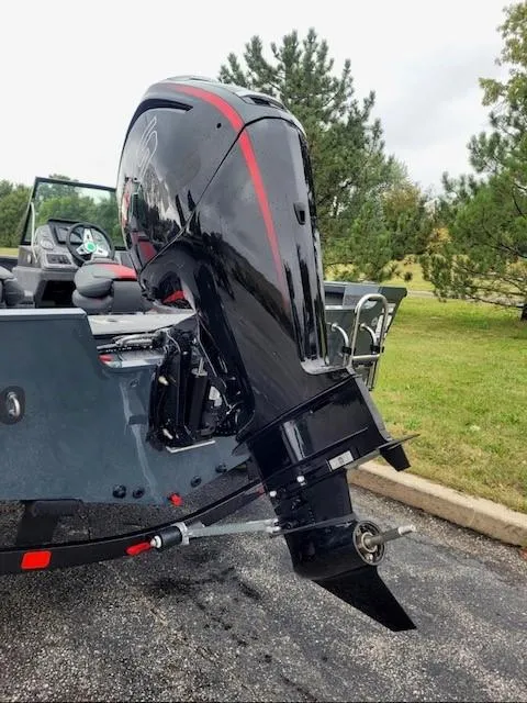 Slide: The Image of 2024 Ranger VS1682SC Angler boat with powerful outboard motor, parked on pavement. - 2