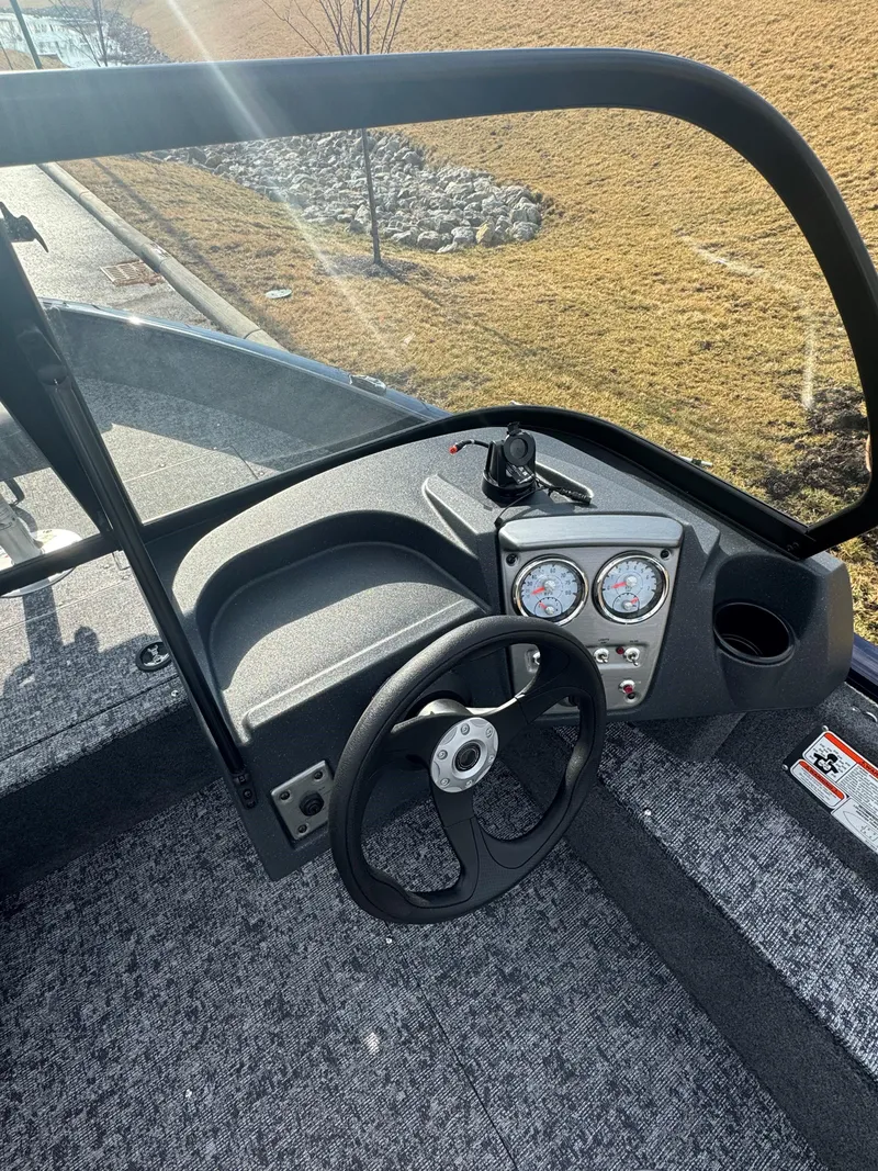 Slide: The Image of 2025 Tracker Pro Guide V-16 WT boat dashboard with steering wheel and gauges. - 5