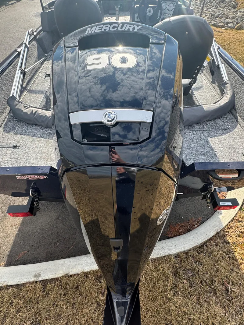 Slide: The Image of 2025 Tracker Pro Guide V-16 WT boat with Mercury 90 engine, parked on grass. - 7