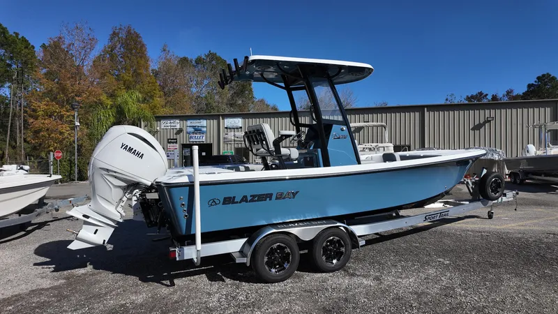 Slide: The Image of 2025 Blazer 2440 boat with Yamaha engine on trailer, parked outdoors. - 15