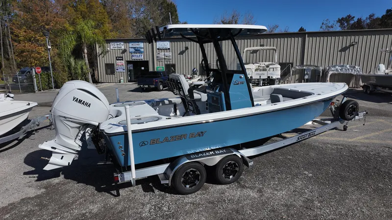 Slide: The Image of 2025 Blazer 2440 boat with Yamaha engine on trailer, parked outdoors. - 16