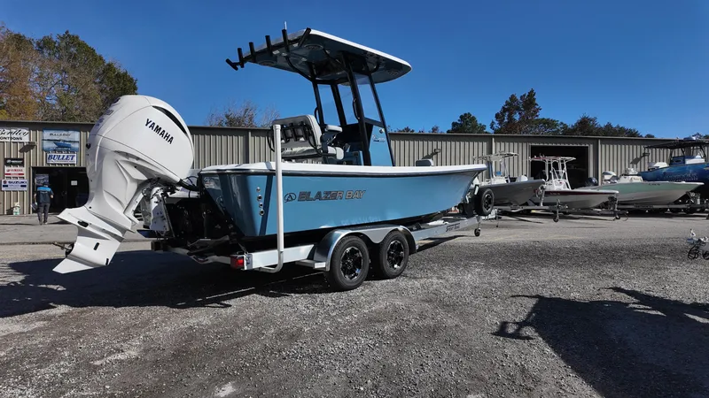 Slide: The Image of 2025 Blazer 2440 boat with Yamaha engine on trailer, parked outdoors. - 19