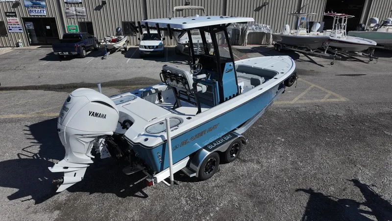 Slide: The Image of 2025 Blazer 2440 boat with Yamaha engine in a marina setting. - 21