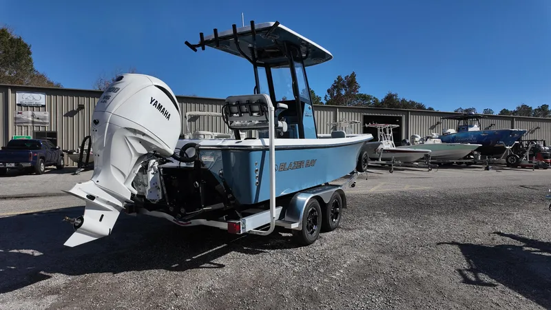 Slide: The Image of 2025 Blazer 2440 boat with Yamaha engine on trailer, parked outdoors. - 22