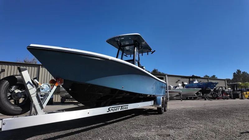 Slide: The Image of 2025 Blazer 2440 boat on trailer under clear blue sky. - 24